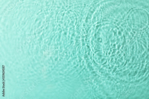 Clear water with rippled surface on turquoise background, top view