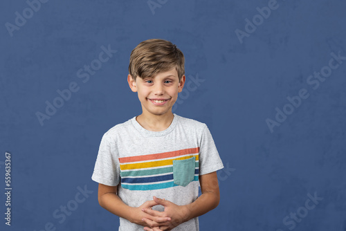 a cute autistic elementary school boy on a blue background with copy space photo