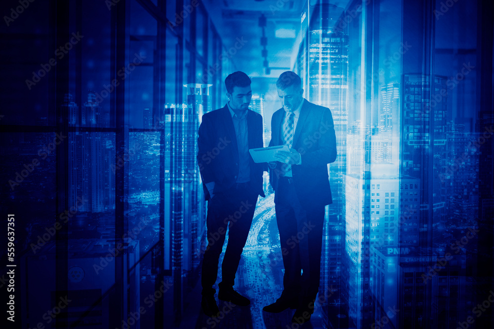 Two men hold tablet with night traffic background Two men hold tablet with night traffic background