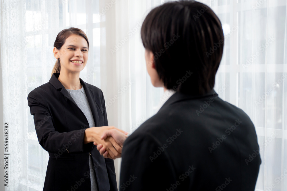 Happy business man and woman standing and shake hands while agreement of negotiation success and congratulations at office, businessman and partner handshake while greeting together, business concept.