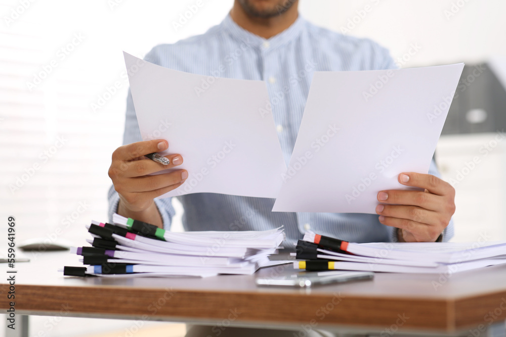 Man working with documents at wooden table in office, closeup Man working with documents at wooden table in office, closeup