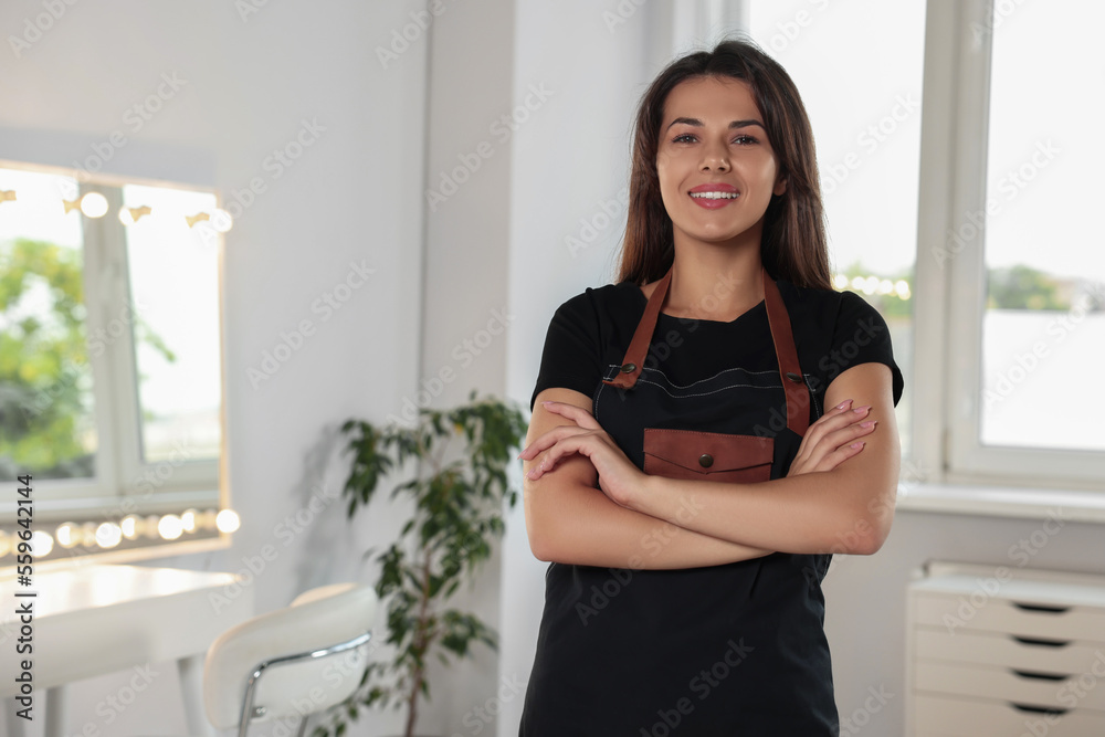 Portrait of happy hairdresser with professional apron in beauty salon. Space for text Portrait of happy hairdresser with professional apron in beauty salon. Space for text