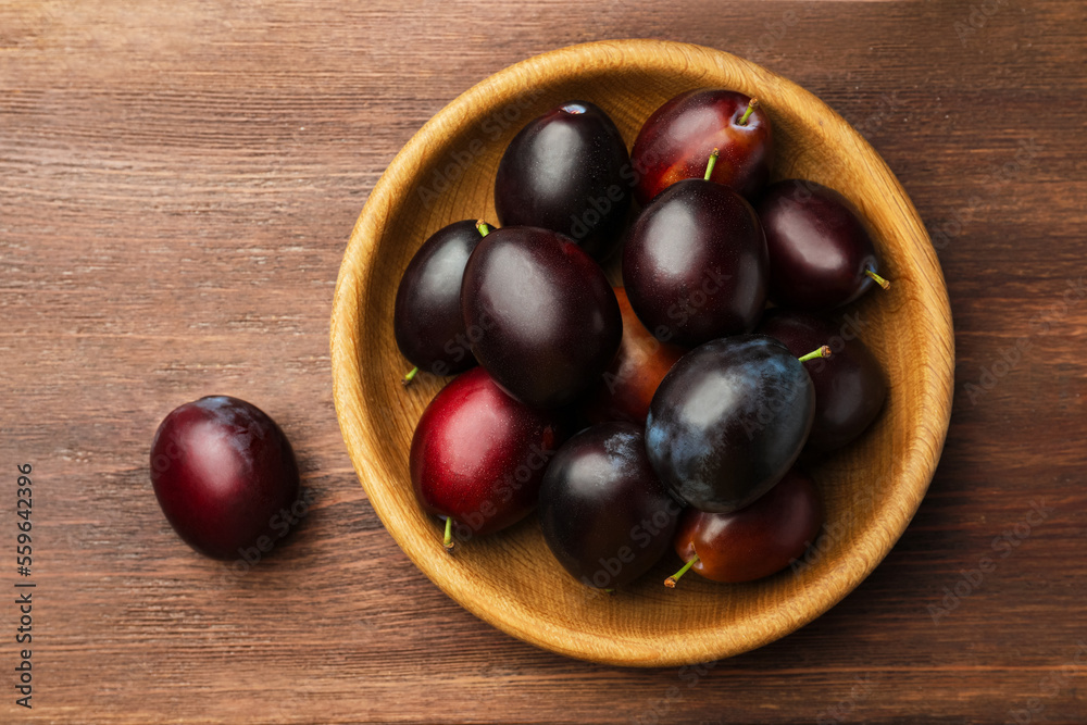 Tasty ripe plums on wooden table, flat lay Tasty ripe plums on wooden table, flat lay