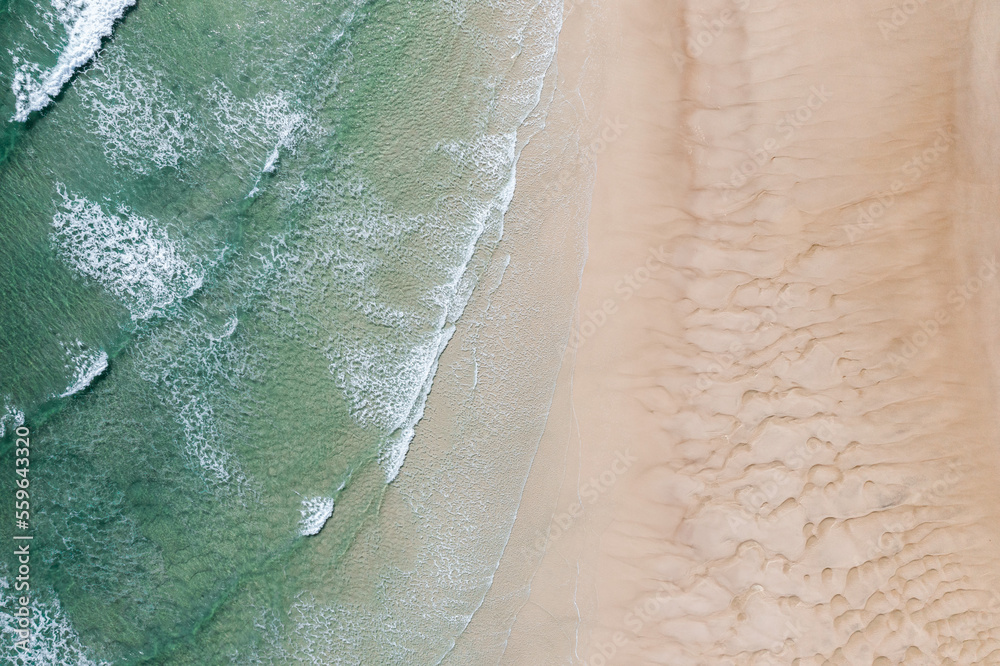 Aerial view of stunning waves crushing near sand banks in a stunning blue water