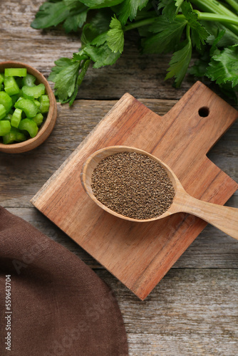 Spoon of celery seeds and fresh plant on wooden table  flat lay
