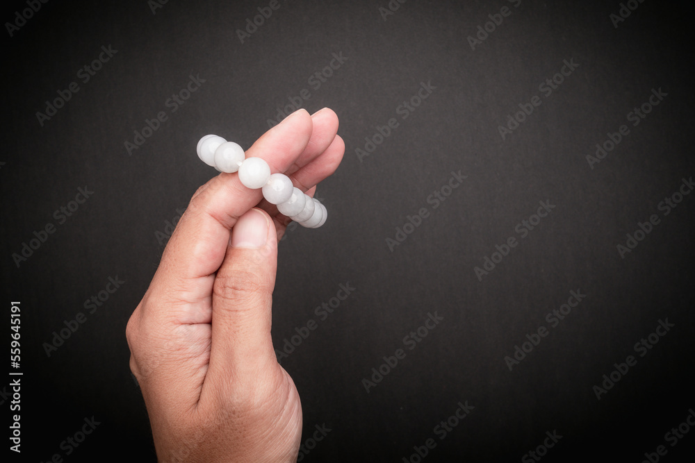 White jade bangles or bracelets in hand against a black background White jade bangles or bracelets in hand against a black background