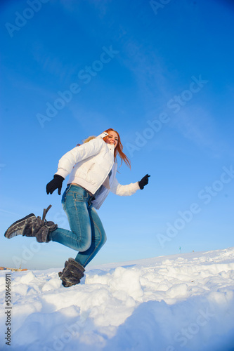 Pretty young woman with red hair take a fun on the snow field