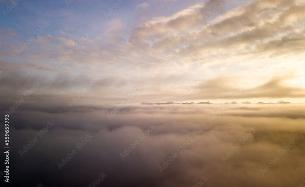 Aerial view of mist, cloud and fog hanging over a lush tropical rainforest after a storm