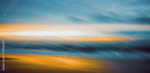 Stormy sea at sunset. Abstract motion blur seascape in bright sunset colors