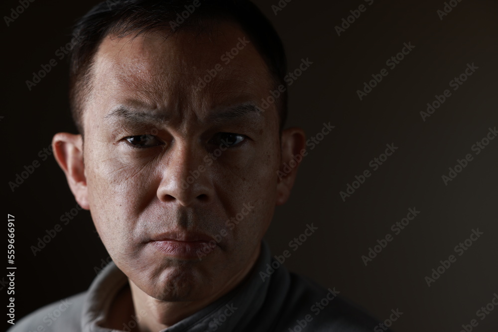 Middle-aged Japanese man in gray casual shirt on gray background. Conceptual image of world peace, stability in daily life, and sustainable living. Middle-aged Japanese man in gray casual shirt on gray background. Conceptual image of world peace, stability in daily life, and sustainable living.