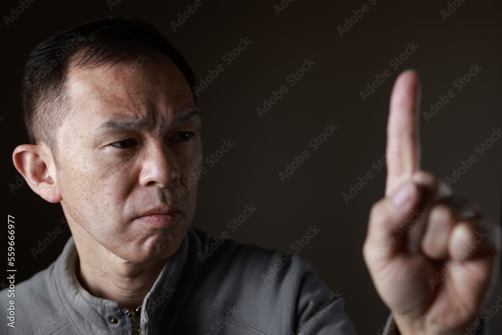 Middle-aged Japanese man in gray casual shirt on gray background. Conceptual image of world peace, stability in daily life, and sustainable living. Middle-aged Japanese man in gray casual shirt on gray background. Conceptual image of world peace, stability in daily life, and sustainable living.