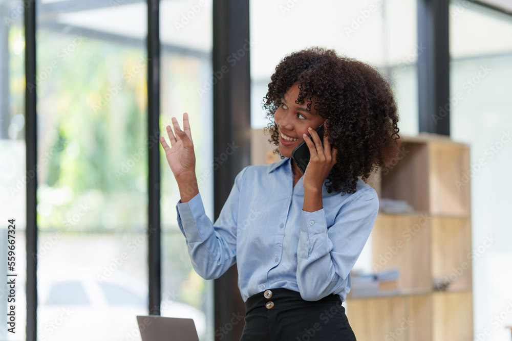 Business black woman having phone conversation with client in office. African american young woman using smart phone Business black woman having phone conversation with client in office. African american young woman using smart phone