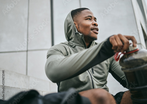 Fitness, gym or black man drinking water after training, exercise or workout for healthy body hydration. Relaxing, mindset or tired sports athlete with goals, motivation or mission resting in Chicago