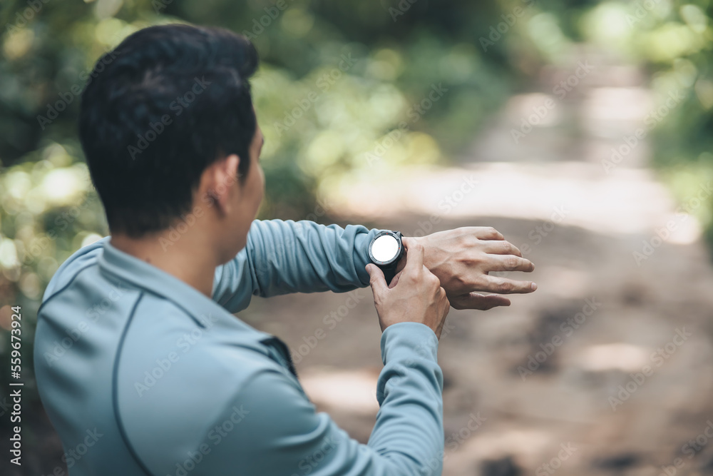sport man checking at smartwatch during training and running in the park. Outdoor workout, Healthy lifestyle concept. sport man checking at smartwatch during training and running in the park. Outdoor workout, Healthy lifestyle concept.