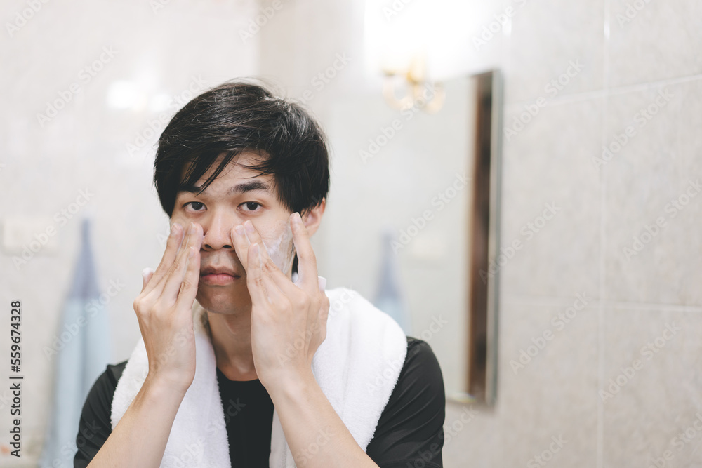 Alone adult asian man looking at mirror skincare routine. Alone adult asian man looking at mirror skincare routine.