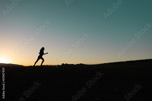girl runs at sunset in the mountains. © zhukovvvlad