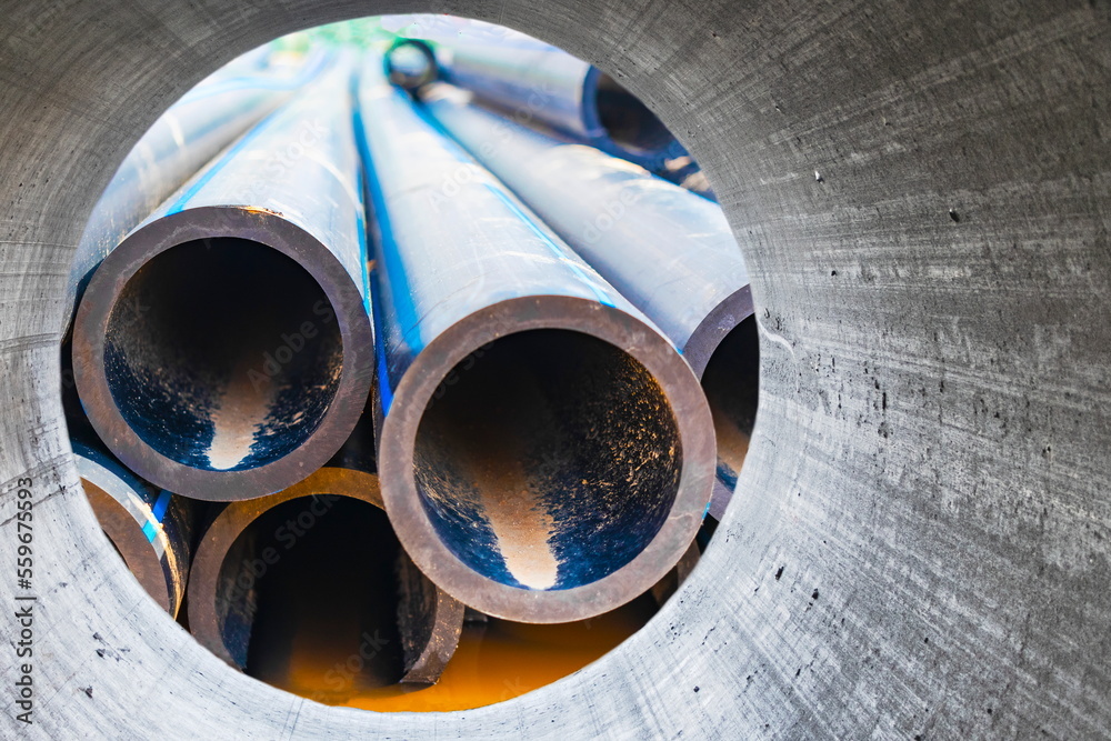Water pipes for drinking water supply lie on the construction site. Preparation for earthworks for laying an underground pipeline. Modern water supply systems for a residential city. Water pipes for drinking water supply lie on the construction site. Preparation for earthworks for laying an underground pipeline. Modern water supply systems for a residential city.