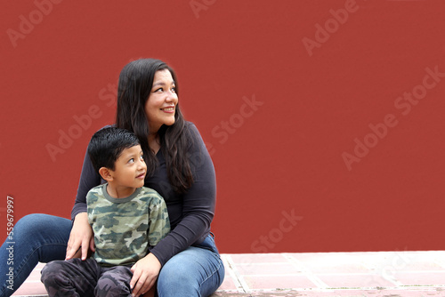 Single mom and dark-haired Latino son play and have fun together spending quality family time on Mother's Day