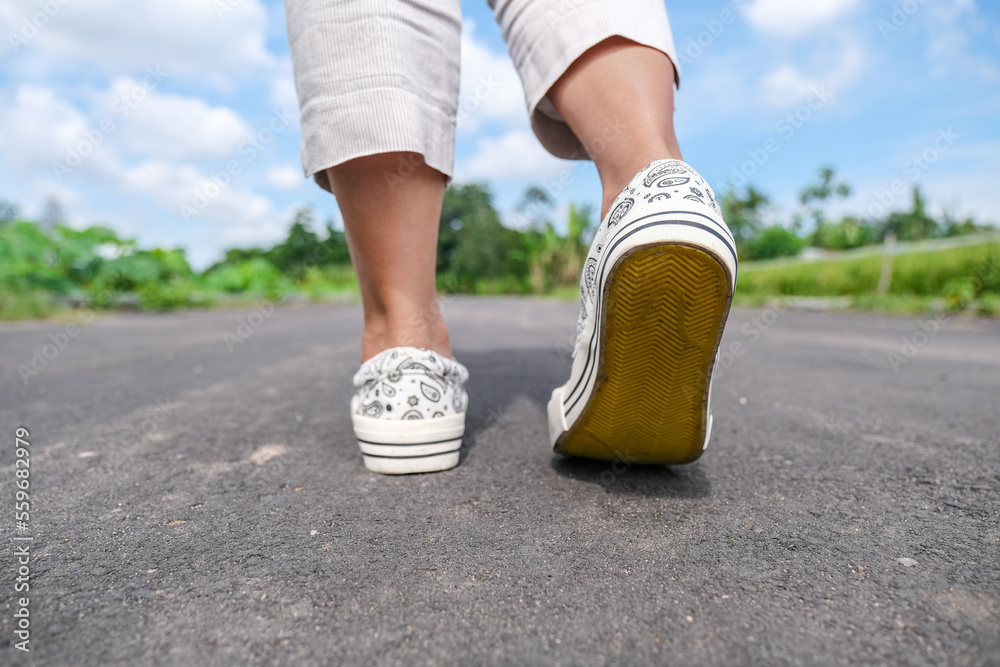 © Simon - Close up shot of a pair of feet wearing sneakers on the road © Simon - Close up shot of a pair of feet wearing sneakers on the road