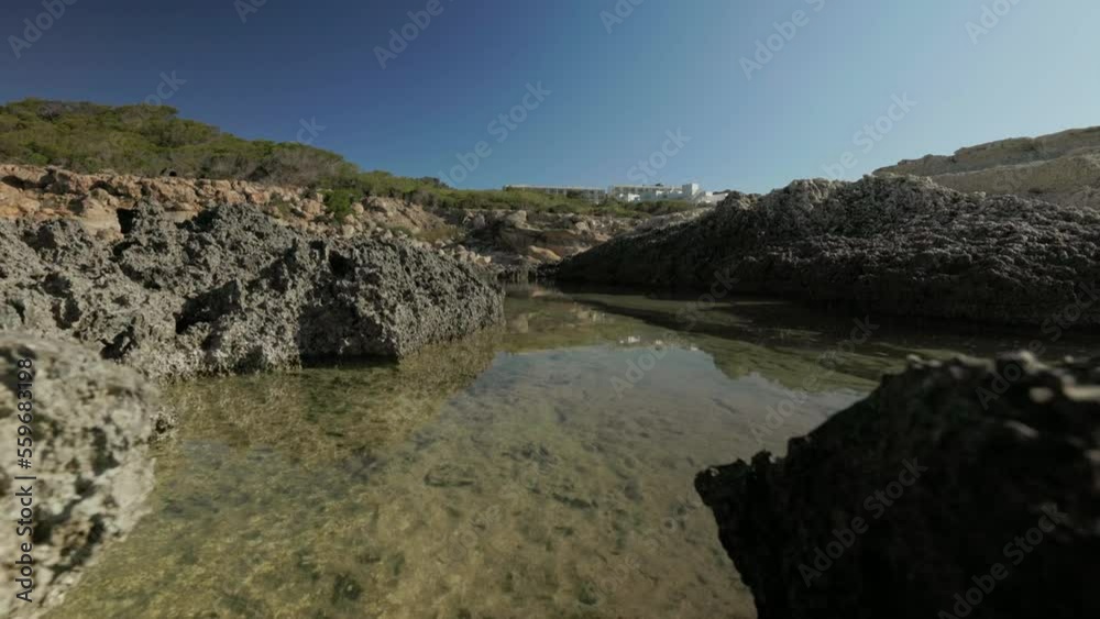 Rock pool on coast of Ibiza island in summer sun. Empty seaside landscape Rock pool on coast of Ibiza island in summer sun. Empty seaside landscape