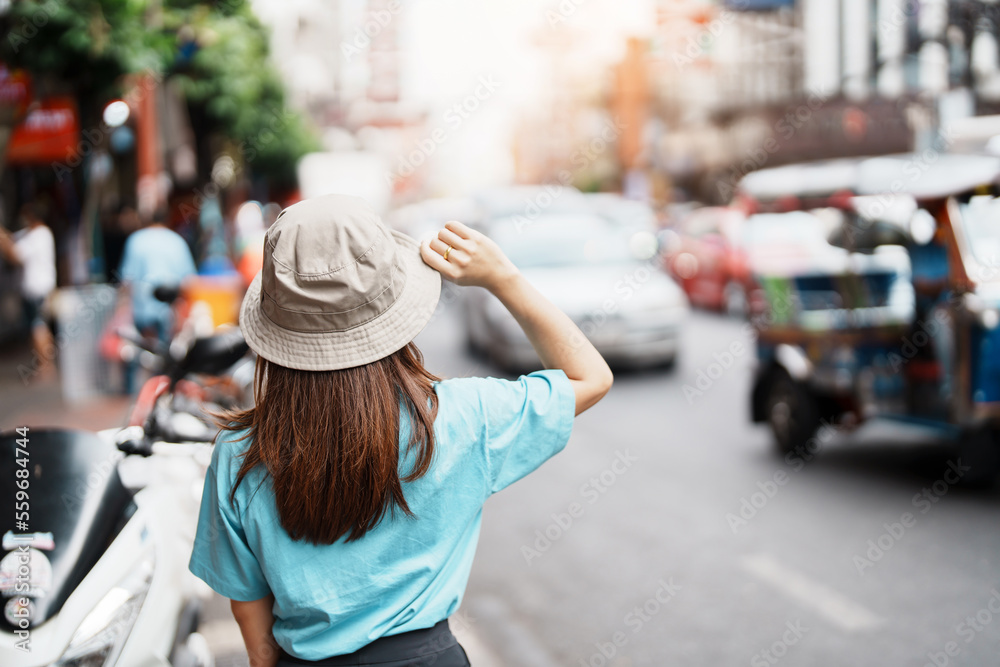 Young Woman with hat traveling in Bangkok, Asian traveler visiting at Yaowarat road or Chinatown of Bangkok, landmark and popular for tourist attractions in Thailand. Southeast Asia Travel concept