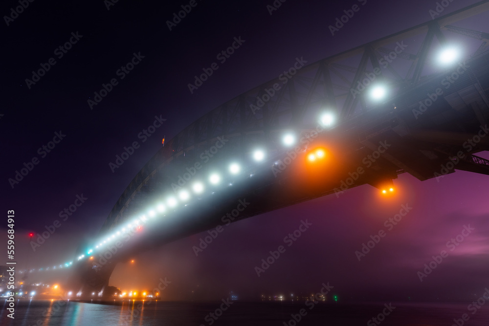 Dawn view of Sydney Harbour Bridge in the fog.
