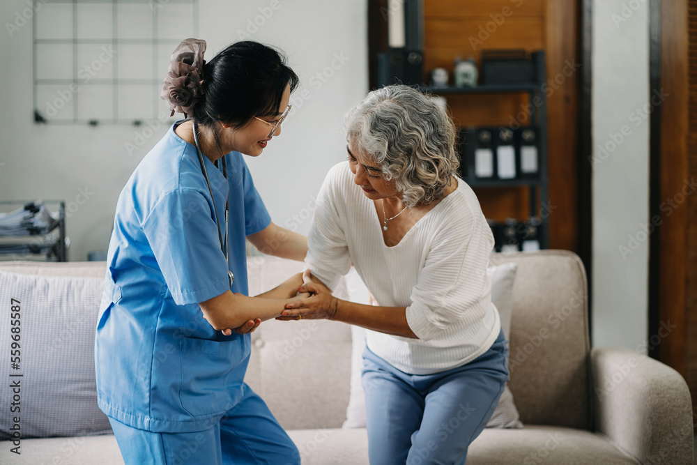 Obraz premium young caregiver assists her elderly woman patient at a nursing home. A senior woman is assisted by a nurse at home.