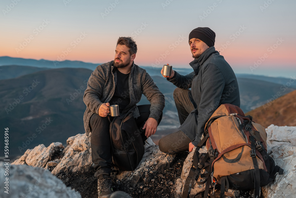 Φωτογραφία Two friends tourists are relaxing while drinking a cup of coffee during the hike on the mountain active healthy lifestyle adventure travel