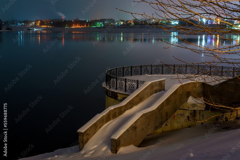Fototapeta premium Granite stairs and terrace over the river under snow in winter.
