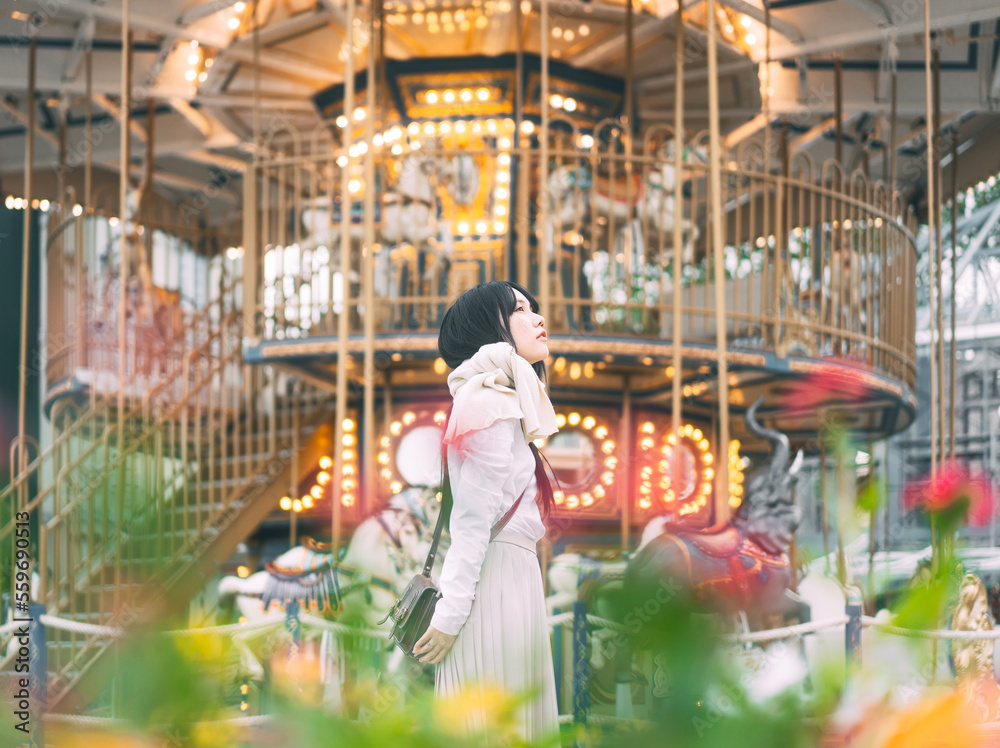 Naklejka premium Portrait of asian woman at outdoor on winter in city with carousel Illumination night background