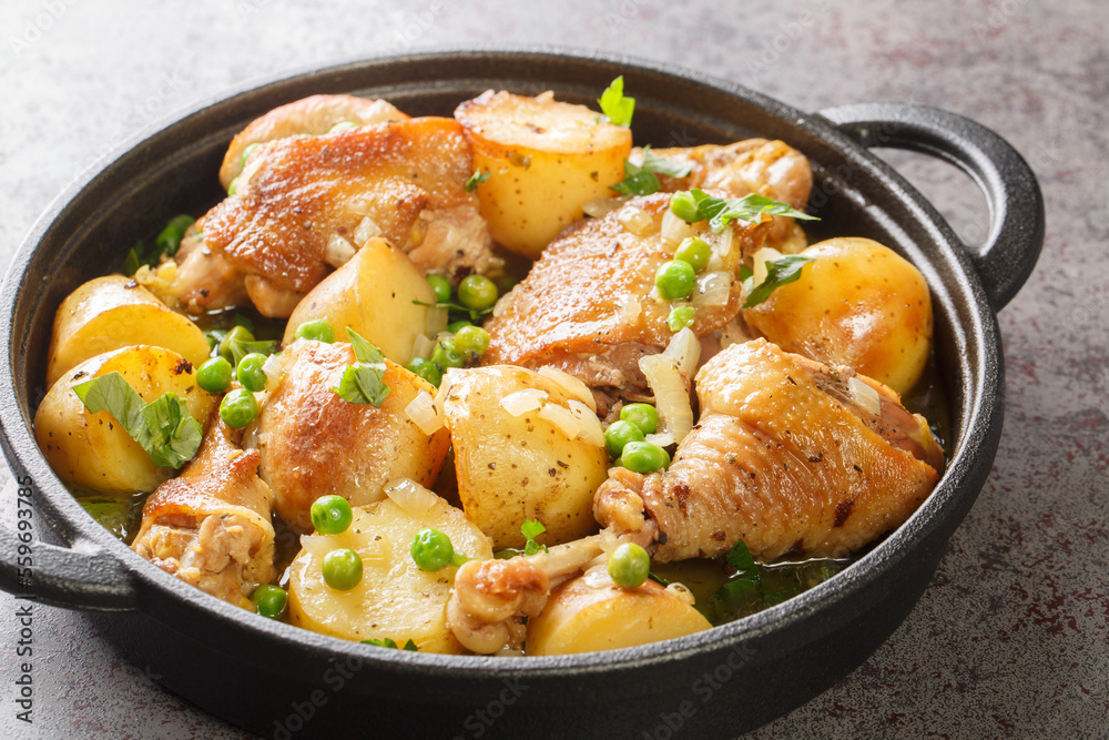 Chicken Vesuvio is pan-seared and baked chicken, potatoes, and peas with a ridiculously delicious herbed wine sauce close-up in a frying pan on the table. Horizontal Chicken Vesuvio is pan-seared and baked chicken, potatoes, and peas with a ridiculously delicious herbed wine sauce close-up in a frying pan on the table. Horizontal