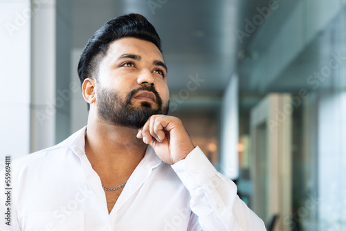 Indian office worker man thinking or planning about future or business forecast