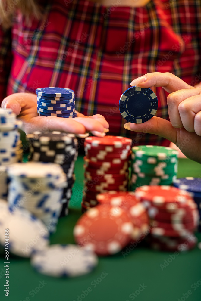 cropped portrait of a young girl playing a men's game at a poker table. cropped portrait of a young girl playing a men's game at a poker table.