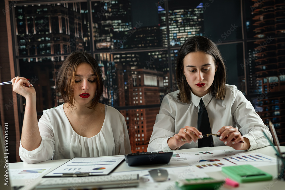 Fototapeta premium Two business woman working together with financial statistics documents
