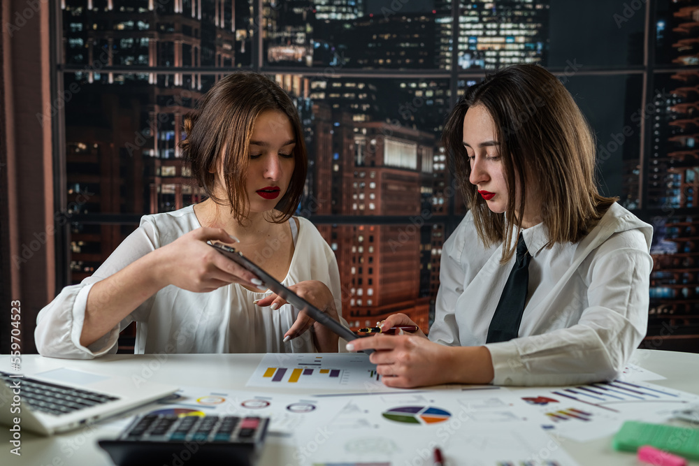 Fototapeta premium Female business team working together on financial document graph
