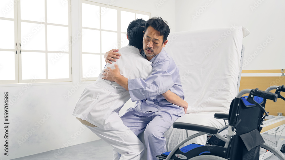ベッドから車椅子へ移乗介助する介護士