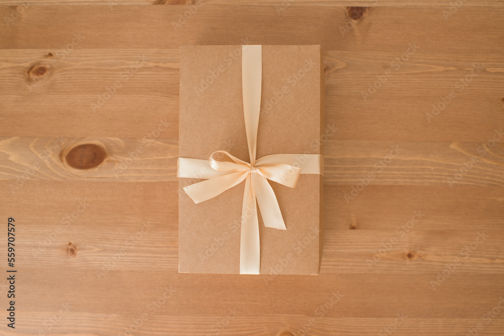 Craft box decorated with ribbon on a wooden table, natural packaging, gift. Craft box decorated with ribbon on a wooden table, natural packaging, gift.