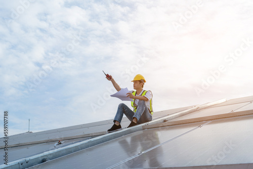 Engineers wearing a uniform walking on roof inspect and check solar cell panel, solar cell is smart ecology energy sunlight alternative power factory concept.
