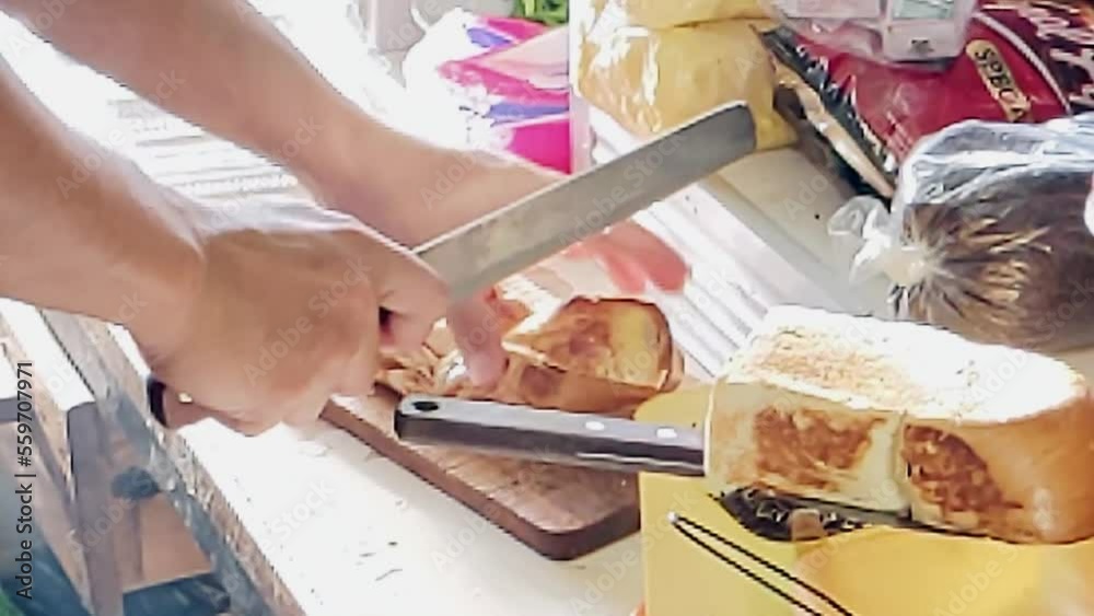 Slow motion. A toasting process of Roti Bakar. The toasting breads known as Roti Bakar is one of favorite breakfast menu for urban workers and best served with a cup of tea or coffee