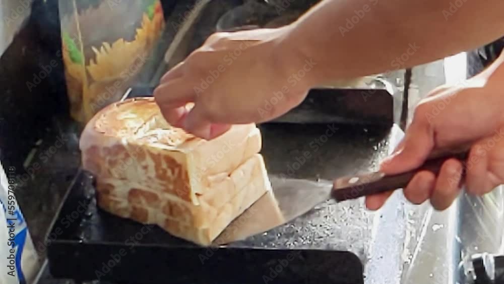 Slow motion. A toasting process of Roti Bakar. The toasting breads known as Roti Bakar is one of favorite breakfast menu for urban workers and best served with a cup of tea or coffee