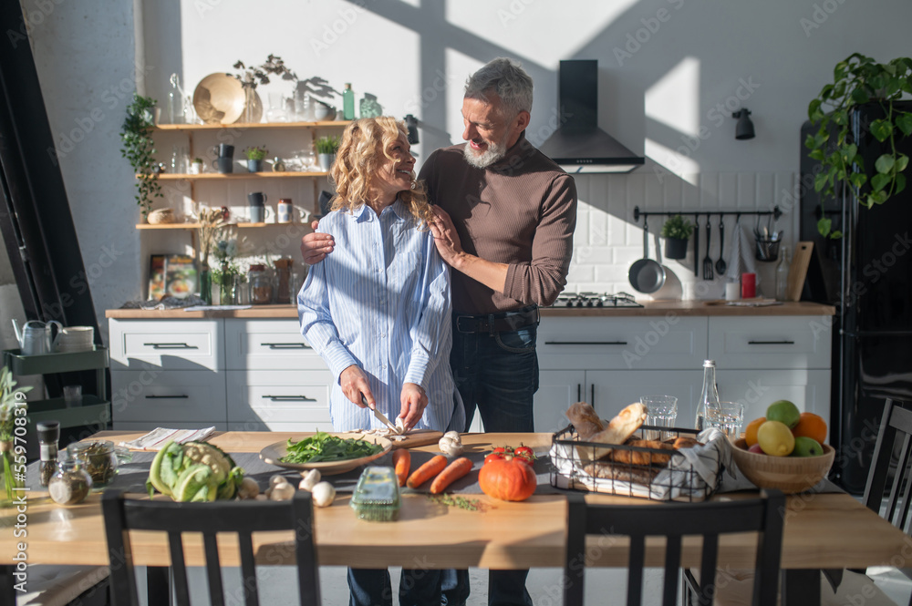 Mature couple cooking together in the kitchen and looking happy Stock ...