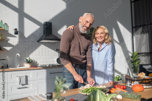 Mature couple feeling good while cooking together in the kitchen