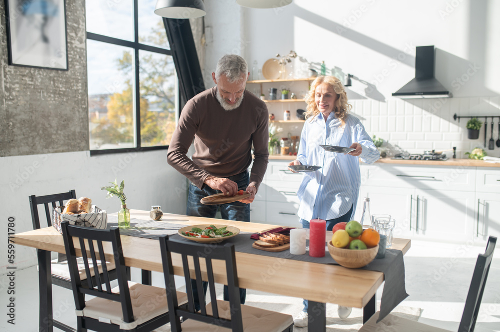 Man and woman serving the table for dinner Man and woman serving the table for dinner