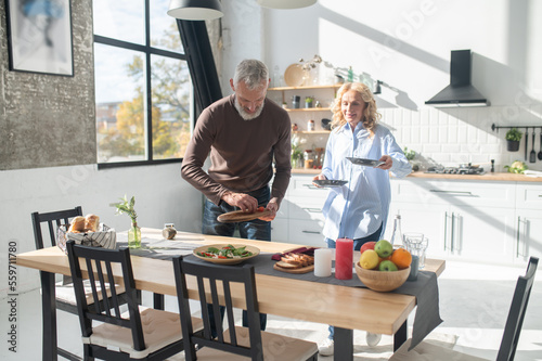 Man and woman serving the table for dinner