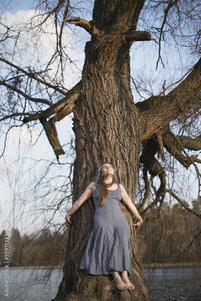 Leaning against willow tree scenic photography. Picture of beautiful authentic woman in dress with nature on background. High quality wallpaper. Photo concept for ads, travel blog, magazine, article Leaning against willow tree scenic photography. Picture of beautiful authentic woman in dress with nature on background. High quality wallpaper. Photo concept for ads, travel blog, magazine, article