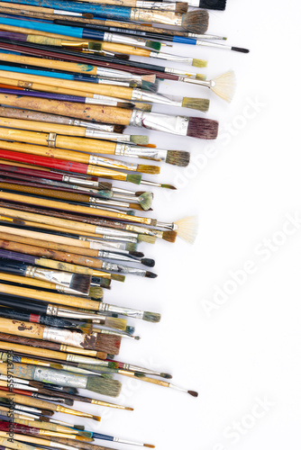 Many brushes for painting on a white background, top view.