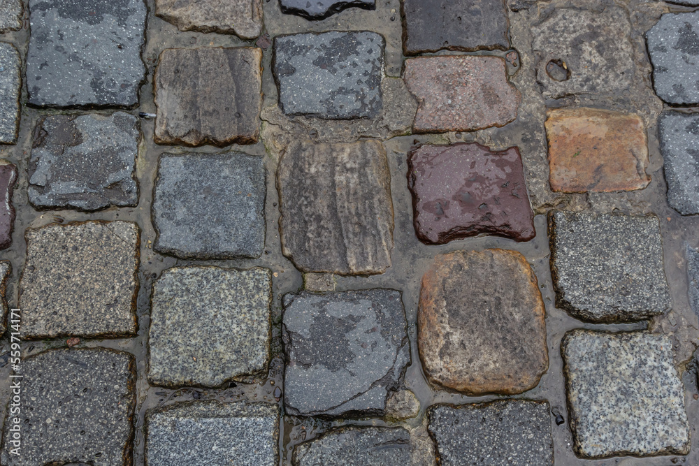 Granite dirty paving stones in the city. Road from paving stones for background and texture. The old road of granite paving stones Granite dirty paving stones in the city. Road from paving stones for background and texture. The old road of granite paving stones