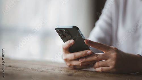 Business man looking at financial information from a mobile phone, he is checking company financial documents, he is an executive of a startup company. Concept of financial management.