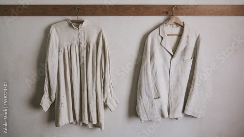 Fotografie Vintage men's shirt and women's dress hang on a hanger against a white wall