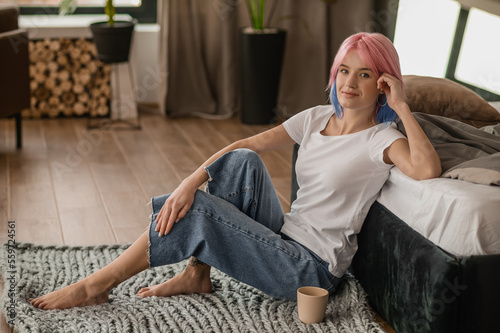 Modern girl whiling away the time in the bedroom photo